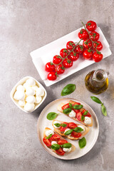 Tomato, basil and mozzarella cheese fresh made caprese bruschetta. Italian tapas, antipasti with vegetables, herbs and oil on grilled ciabatta and baguette bread. Open sandwich.