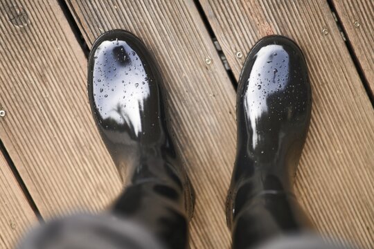 Gl&auml;nzender Gummistiefel  auf Terrassendiele