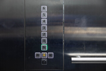 braille signage on elevator buttons on the stainless steel wall. elevator button with number and...