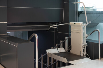 a stair lift for the disabled, wheel chair lift for stairs. Mechanical chair lift taking disabled or aged people up and down stairs.