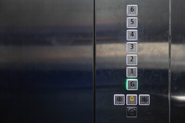 braille signage on elevator buttons on the stainless steel wall. elevator button with number and braille letter.