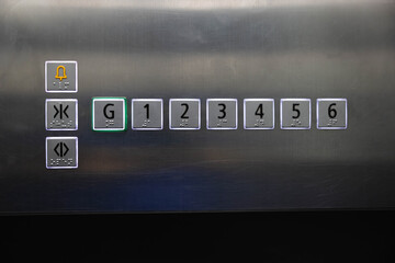 braille signage on elevator buttons on the stainless steel wall. elevator button with number and...