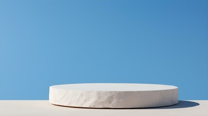 Fototapeta na wymiar Round Stone Podium in front of a blue Studio Background. White Pedestal for Product Presentation
