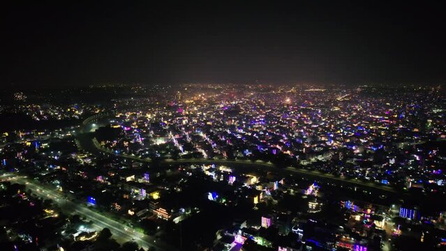 aerial drone shot flying forward over jaipur, indore, Ahmedabad, chandigarh city showing fireworks and houses metro rail decorated with lights on the eve of diwali makar sankranti showing the