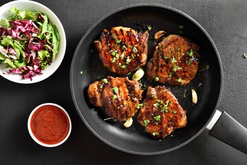 Roasted pork steaks in pan