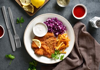 Schnitzel with potato fries, cabbage salad and sauce