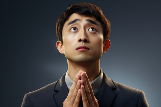 A man dressed in a suit is captured in a moment of prayer. This image can be used to portray spirituality, faith, or meditation. It can also be used to represent a person seeking guidance or solace.