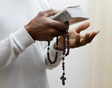 man praying to God with the bible on black background with people stock image stock photo	