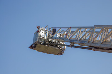 firefighter ladder nacelle platform firetruck climbing equipment on blue sky
