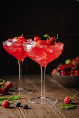 Glass of berry cocktail with fresh berries on wooden background