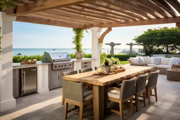 Foto op Canvas A coastal outdoor kitchen featuring a white pergola, a built-in grill with a reclaimed wood surround, and a dining area with a driftwood table and slipcovered chairs © RBGallery