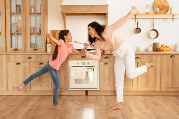Happy Mom And Daughter Kid Dancing And Singing In Kitchen