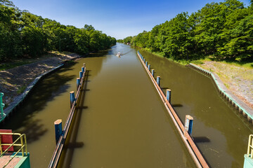 Beautiful view of boat entrance to water level mechanism with dirty water with beautiful green trees and bushes on both sides of river