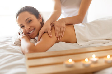 Obraz na płótnie Canvas Lady having body massage lying on table at spa salon