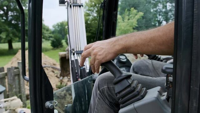 Person operating hand controlling the joystick of excavator
