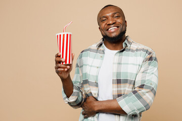 Young man of African American ethnicity he wear light shirt casual clothes hold in hand cup of soda...