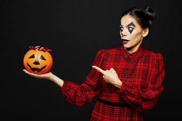 Young scared woman with Halloween makeup face art mask wear clown costume red dress hold...