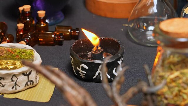 Witchcraft composition selective focus with candles lights, magic items tools and symbols.  Occult and esoteric concept. Mystic Halloween. Magic chemistry and witch craft.
