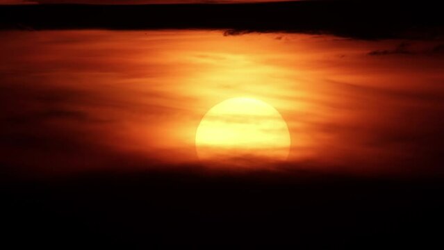 African sunset time lapse with big sun disk and backlit clouds. Cinematic and epic hot summer sunset timelapse with big red and orange sun circle.