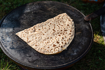 Woman cooking traditional turkish gozleme pancakes outdoors on street market