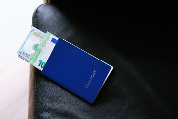 Blue passport with money inside on the sofa.
