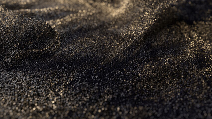 Black glitter with gold flecks. Golden loosened sand on ground.