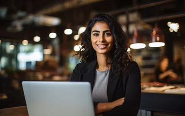 Foto op Plexiglas Portrait of young Indian smiling businesswoman using laptop in office, strong women concept © perfectlab