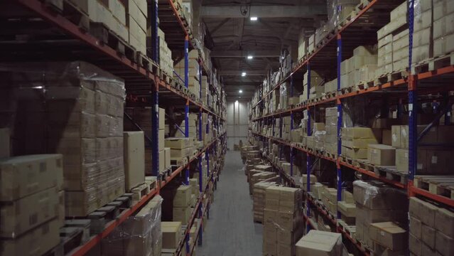 Rows of shelves inside industrial warehouse with boxes.