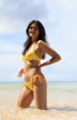 Portrait sexy woman with yellow bikini post on tropical beach