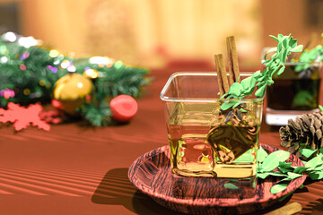 Winter bourbon with ice and vermut, cinnamon and rosemary on wooden table with tree branches and christmas decor on a defocused background. Top view. 3d render.