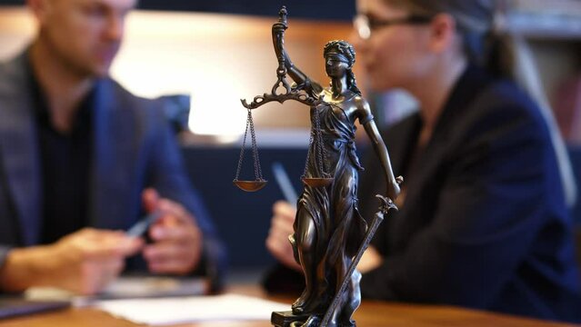 A lawyer meets with a new client. A young male lawyer in a suit sits at an office desk, shares legal advice, explains the inheritance process, tries to help. Legal advice concept