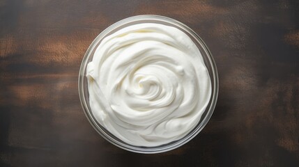 Whipped cream for cakes in glass bowl, top view, copy space