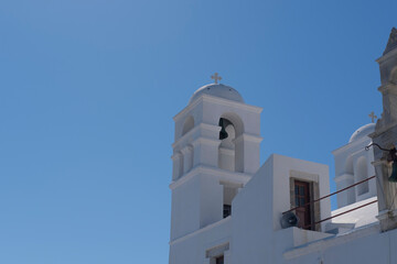 typical white greek church bell tower on bright blue sky