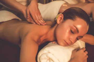 Tuinposter Caucasian couple customer enjoying relaxing anti-stress spa massage and pampering with beauty skin recreation leisure in warm candle lighting ambient salon spa at luxury resort or hotel. Quiescent © Summit Art Creations
