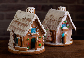 Two Christmas gingerbread houses decorated with sugar icing and colorful candy