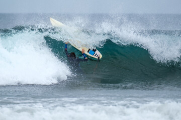 Girl surfing caught in a wave