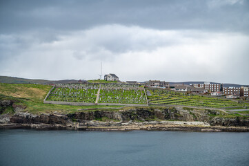 Fototapeta premium Shetland Islands Cityscape and old graveyard with sea in front, wide angle shot, view from the distance, Scotland