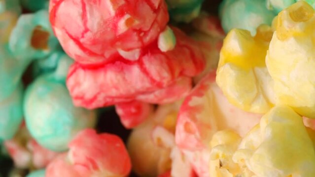 Colored popcorn, rotation in a circle. Close-up of sweet popcorn. Vertical video