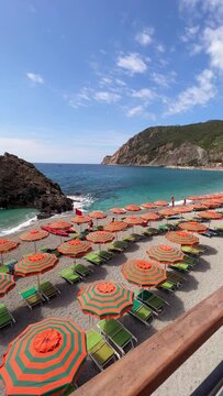 beach with umbrellas and chairs in cinque terre italy