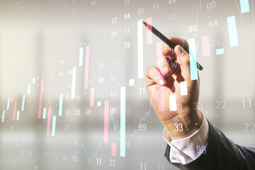 Man hand with pen working with abstract virtual financial graph on blurred office background, forex...