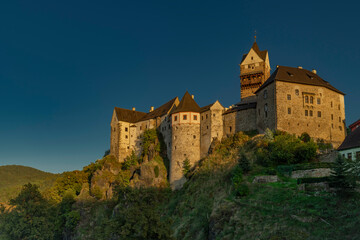 Loket town with castle on hill and river Ohre around in autumn evening