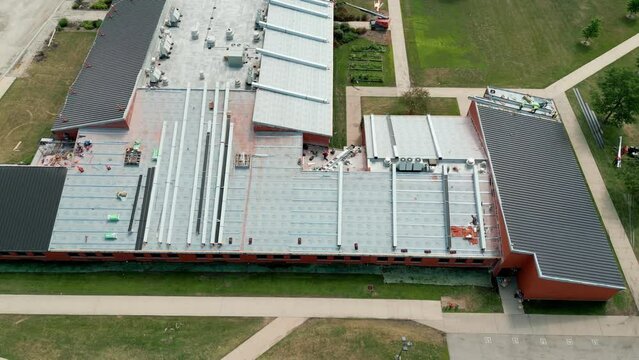 Drone view of an industrial roof, Roofers installing a new roof on an industrial building. Above view footage