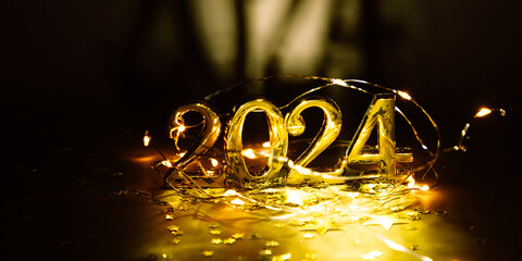 Golden digits in 2024 number with gold decorations on dark background. 2024 new year backdrop. Space for text