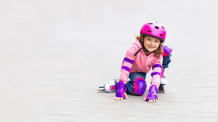 Little cute girl rollerblading in purple, protection, pink helmet in the city in summer, autumn. Child roller skating. Female in inline skates. Active sport kids. banner, copy space, text