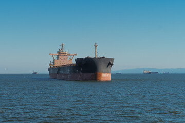 Obraz premium Cypress flagged bulk carrier ship Macheras moored in San Francisco Bay before heading up the San Joaquin River to the Port of Stockton.