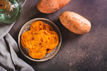 Pieces of sweet baked potatoes on a plate on the table top view