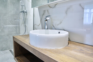 Shower room interior in marble white gray tiles, with countertop round washbasin