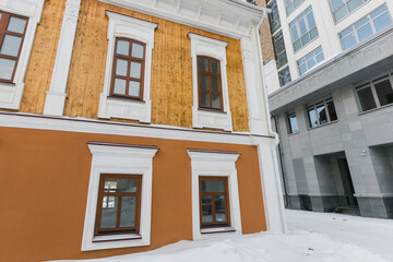 Street with houses cold weather. Snow day in winter. Building in city center covered with snow.