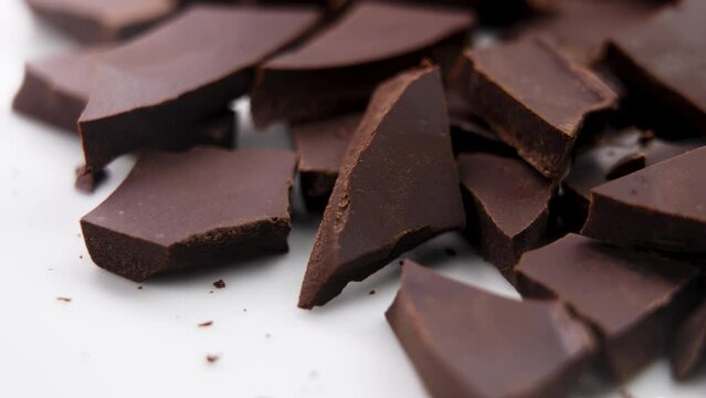 Chopped crushed dark chocolate chunks close up. Rotation