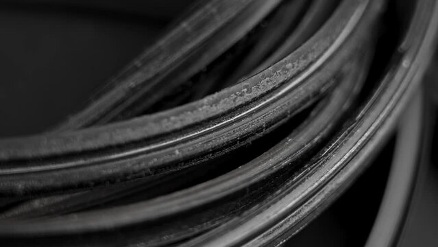 Old black insulating rubber window flex seal. Close up. Rotation. Abstract view